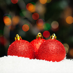 Christmas background with red baubles and abstract bokeh light
