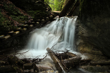 Dangerous trail through a waterfall with wooden ladders in the Slovak Paradise National Park,...