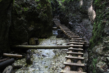 Dangerous trail through a waterfall with wooden ladders in the Slovak Paradise National Park,...