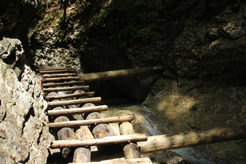 Dangerous trail through a waterfall with wooden ladders in the Slovak Paradise National Park, Slovaki