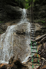 Dangerous trail through a waterfall with steel ladders in the Slovak Paradise National Park, Slovaki