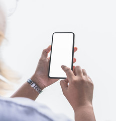 Close-up image of a business woman's hands holding and showing smartphone with blank white screen background.