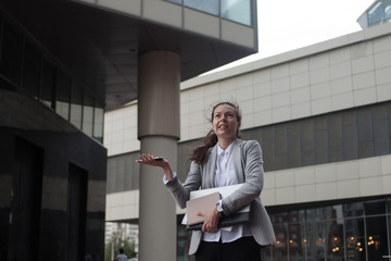 Disappointed young woman is a businesswoman, standing on the background of the business center.