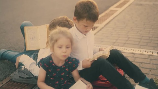 little blonde girl in black dress talks to schoolmates during preparation for difficult exams close view