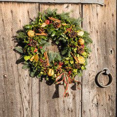 A traditional Christmas wreath on an Elizabethan (16C) oak entrance door (close up)