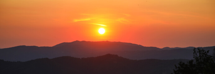Fototapeta na wymiar Sonnenuntergang über einer Hügellandschaft, Toskana, Italien