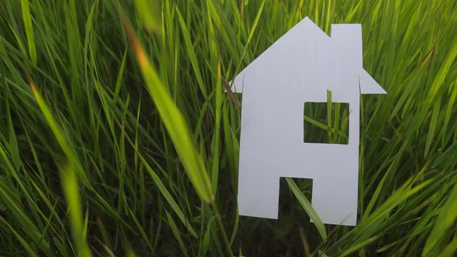 building happy family construction house concept. paper house stands in lifestyle the green grass in nature. symbol life ecology video