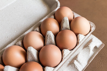 Close-up view of raw chicken eggs in egg box.