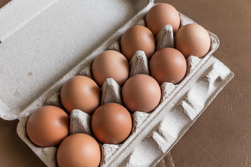 Close-up view of raw chicken eggs in egg box.