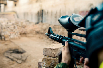 First person view of paintball player fully equipped on paintball battlefield 