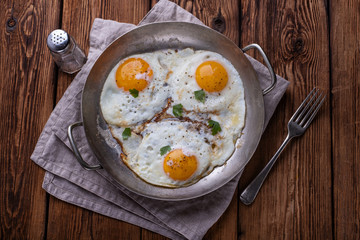 Fried eggs on white wooden background