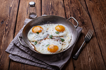 Fried eggs on white wooden background