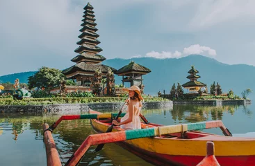 Foto auf Acrylglas Bali Schönes Mädchen, das auf dem Katamaran am Ulun Datu Pura Bratan Tempel in Bali Kajak fährt