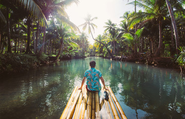 Palm tree jungle in the philippines. concept about wanderlust tropical travels. swinging on the river. People having fun - obrazy, fototapety, plakaty