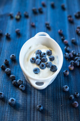 fresh tasty blueberry with natural yoghurt on wooden background
