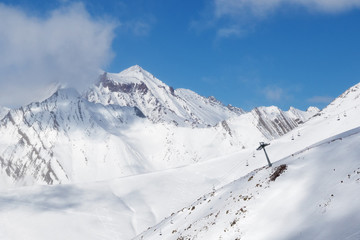 Fototapeta na wymiar Off-piste slope and chair-lift on ski resort at sun day