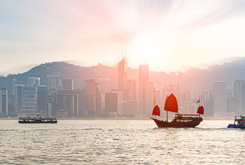 Traditional Chinese junk boat  crossing Victoria Harbor between Kowloon and Hong Kong island