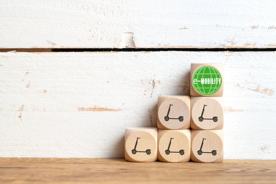 cubes with electric scooter symbols on wooden background