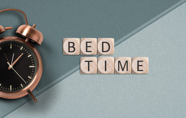 cubes with message "bed time" and alarm clock on paper background