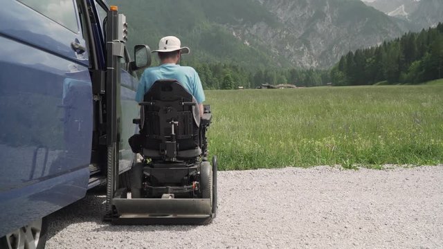 4k resolution video of A man on wheelchair going out of a car on electric lift specialized vehicle for people with disabilities. Self help for disabled people concept