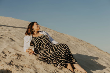Outdoor fashion portrait of plus size woman wearing trendy animal print. Attractive curvy woman on the background of the desert and blue sky. Stylish accessories, summer dress, bag and jacket