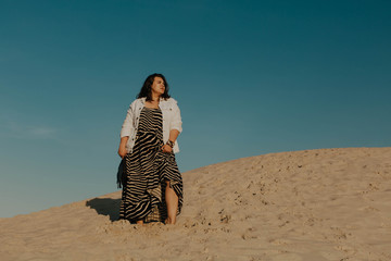 Outdoor fashion portrait of plus size woman wearing trendy animal print. Attractive curvy woman on...