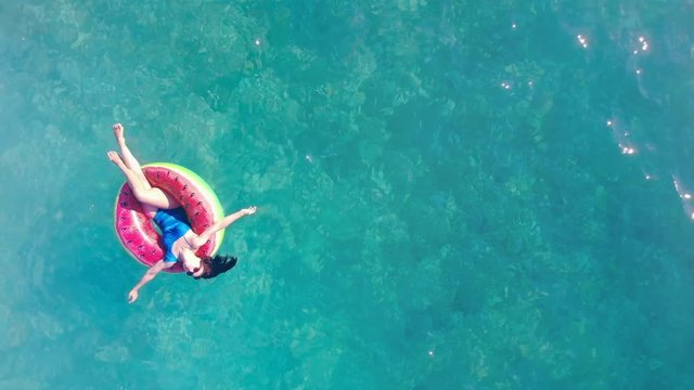 Girl floats in a pool on a rubber ring.