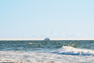 the ship sails on rough seas near the shore