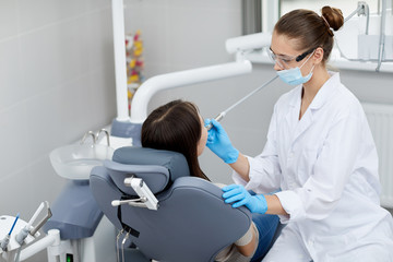 High angle portrait of female dentist examining child in clinic, copy space