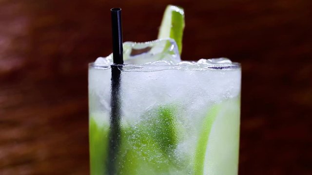 Typical drink from Brazil called Caipirinha, made with lemon and sugar with cacha&ccedil;a. Favorite cocktail of Brazil, isolated over wood texture.