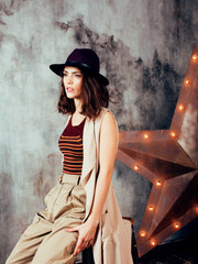 young pretty woman waiting alone in modern loft studio, fashion clothers wearing hat, lifestyle and...