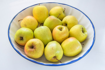 Yellow apples in a ceramic bowl