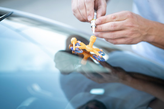 Reparatur eines Steinschlags in der Frontscheibe eines Autos