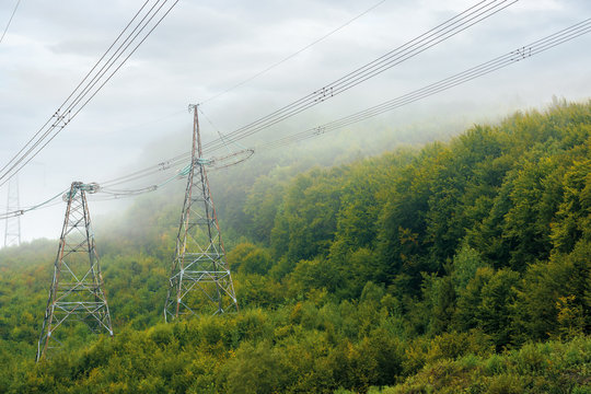 high voltage power lines tower in mountains.  energy delivery background. efficient electricity delivery concept. hazy weather with overcast sky