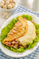 Fried omelet stuffed with ham, mushrooms and cheese