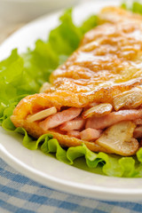 Fried omelet stuffed with ham, mushrooms and cheese