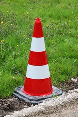 striped pylon is standing at the side of the street