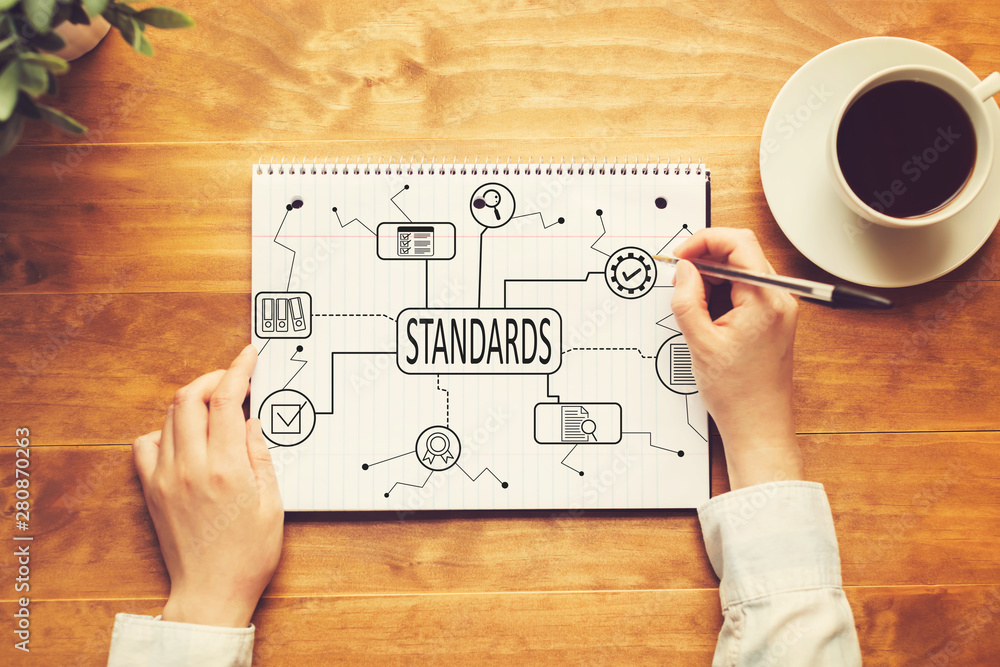 Poster standard quality control approval with a person writing in a notebook on a wooden table