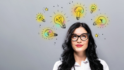 Idea light bulbs with young businesswoman in a thoughtful face