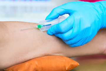 Health and Medical concept. Hands nurse are using needle to pierce vein Preparation for blood test on table.