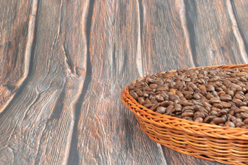 Plakat coffee grains in wicker plate on wooden background