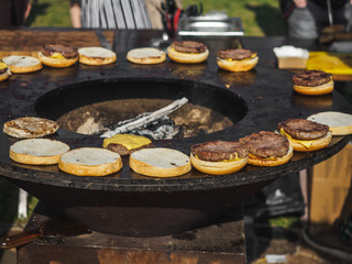 Cooking burgers with beef meat in grill bbq street festival