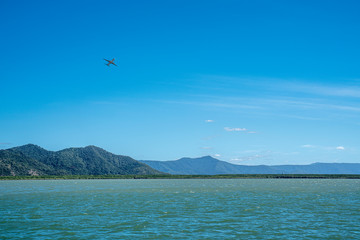 Obraz na płótnie Canvas Jet airliner climbing over the water after having taken off at Cairns airport, Australia