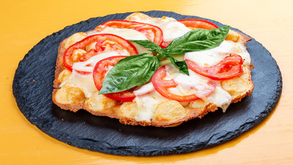 Bubble waffles with mozzarella, tomatoes and basil.
