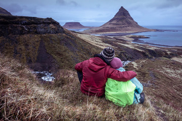 Fototapeta premium Couple sitting near Kirkjufell during blue hour - iceland - Winter