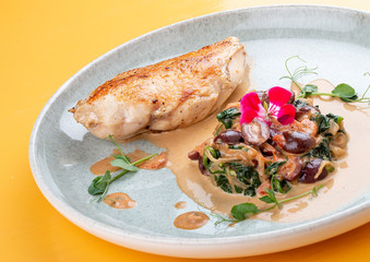 Fried chicken breast, with stewed spinach and grapes.