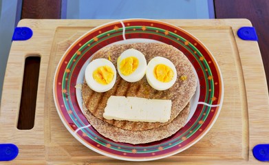 Desayuno con huevos, queso y pan integral.