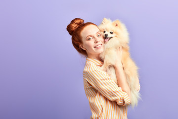 pleasant girl embracing the pet, woman has addopted nice dog. close up portrait, isolated blue background studio shot.closeness, affection