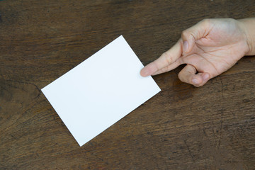 Obraz premium A6 Flyer / Postcard / Invitation Mock-Up - hands holding a blank flyer on a on a wooden table background.
