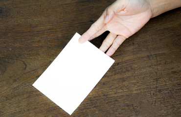 A6 Flyer / Postcard / Invitation Mock-Up - hands holding a blank flyer on a on a wooden table background.
